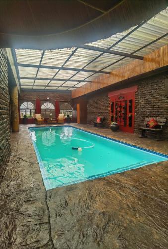 a large swimming pool in a building with a ceiling at Camelot Guesthouse in Newcastle