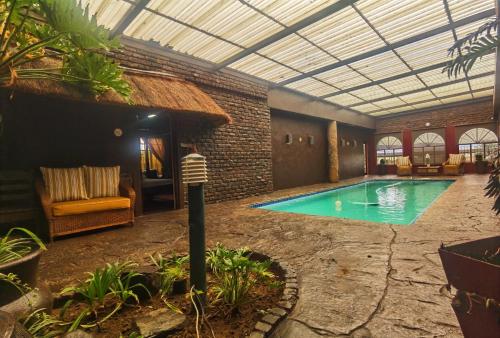 a swimming pool in a building with a ceiling at Camelot Guesthouse in Newcastle