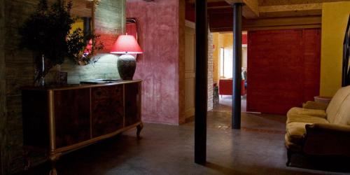 a living room with a couch and a lamp on a dresser at L'Isola Di Rosa - Relais & Hotel di Charme in Cerveteri
