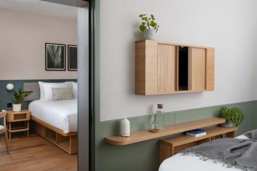 a bedroom with a bed and a mirror at Inhabit Queen's Gardens, a Member of Design Hotels in London