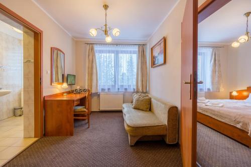 a bedroom with a bed and a desk and a sink at Hotel Diament in Szklarska Poręba