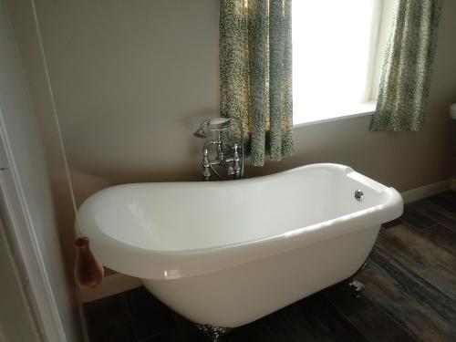 a white bath tub in a bathroom with a window at Bro Arran in Dolgellau