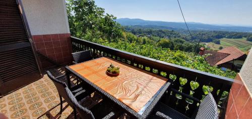 a table and chairs on a balcony with a view at Vineyard Cottage with Private Jacuzzi in Metlika
