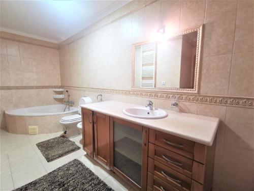 a bathroom with a sink and a tub and a toilet at Anamar in Nazaré