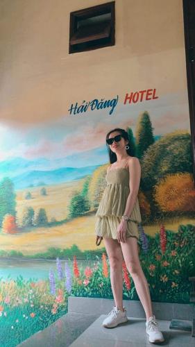 a woman in a dress standing in front of a painting at HAI DANG HOTEL in Xóm Ðé