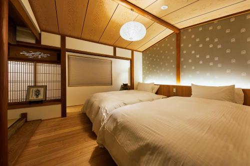 a bedroom with two beds and a window at Gion Shirakawa no Yado in Kyoto