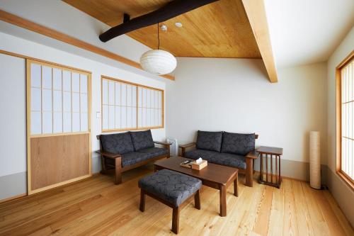 ein Wohnzimmer mit 2 Sofas und einem Tisch in der Unterkunft Gion Shirakawa no Yado by YADORU KYOTO HANARE in Kyoto