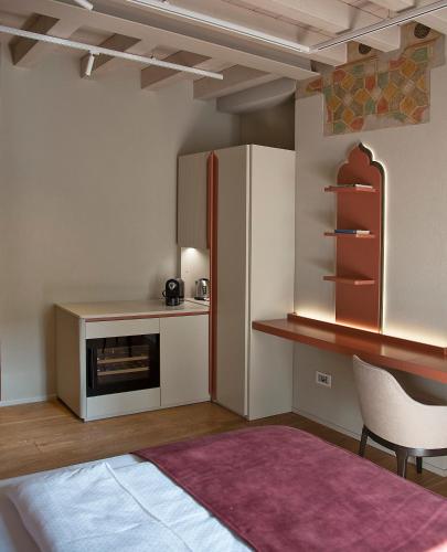 a kitchen with a refrigerator and a table and a chair at Relais Balcone di Giulietta in Verona