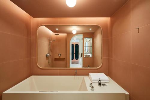 a bathroom with a sink and a large mirror at The Standard, Bangkok Mahanakhon in Bangkok