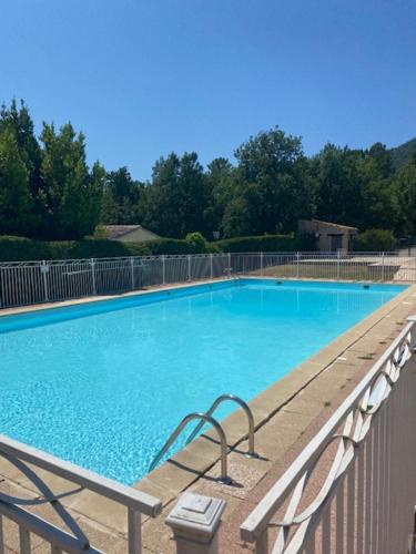 une grande piscine bleue à côté d'une clôture dans l'établissement MAZET 6 pers. (Piscine) 20 mn de FREJUS/St MAXIME, à Plan Florent