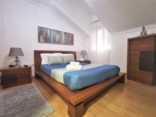 a bedroom with a large bed with a blue blanket at Anamar in Nazaré