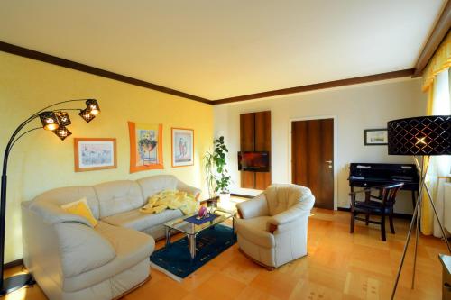 a living room with a couch and two chairs and a piano at Ferienappartement Regina in Schrems