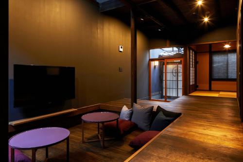 uma sala de estar com duas mesas e uma televisão de ecrã plano em YADORU KYOTO HANARE Kanade No Yado em Quioto