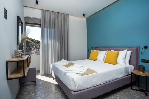 a bedroom with a large bed with yellow pillows at GM Apartments-Rhodes Luxury Living in Kalithies