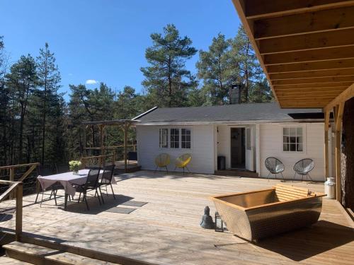 una casa y un patio con mesa y sillas en Summer cabin in Nesodden open-air bath large terrace, en Brevik