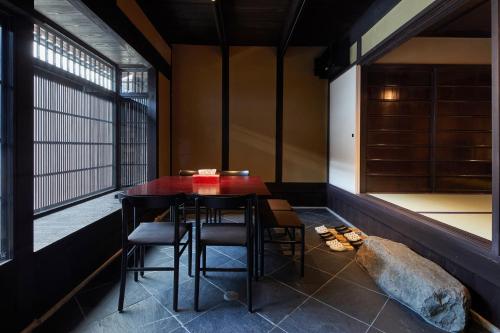 mesa y sillas en una habitación con ventana en Kyoto Urushiro Wakasaya by YADORU KYOTO HANARE en Kioto