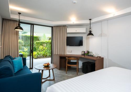 a hotel room with a bed and a blue couch at Dewa Phuket Resort & Villas, Nai Yang Beach in Nai Yang Beach