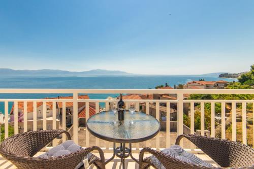 a table and chairs on a balcony with the ocean at Apartments Tilda in Brist