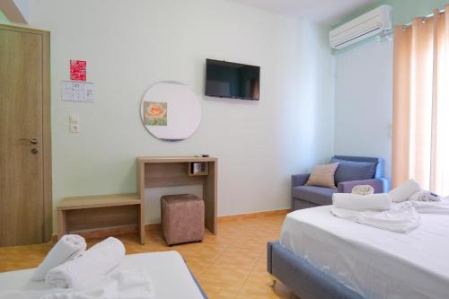 a room with two beds and a couch and a mirror at Hotel Driloni in Ksamil
