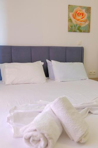 a bed with white sheets and a towel on it at Hotel Driloni in Ksamil