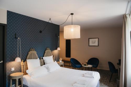 a hotel room with a white bed and chairs at Hotel la Robeyere; BW Signature Collection in Embrun