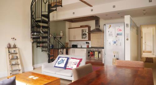 a living room with a dining room table and a kitchen at Ebrington Street View in Plymouth