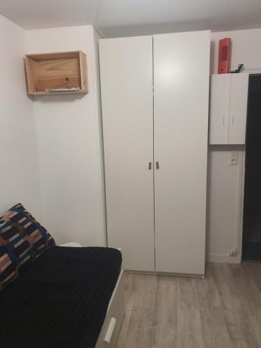 een witte slaapkamer met een bed en een kast bij Côté Ré in Saint-Martin-de-Ré