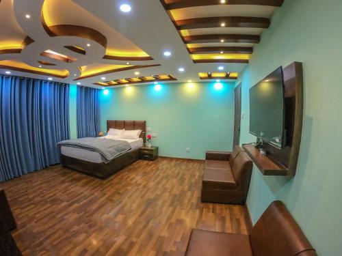 a bedroom with a bed and a flat screen tv at Greenery View Point Resort in Kathmandu