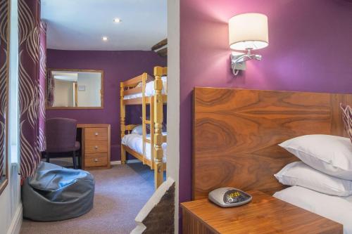 a bedroom with purple walls and a bunk bed at Best Western Plus Sheffield Mosborough Hall Hotel in Sheffield