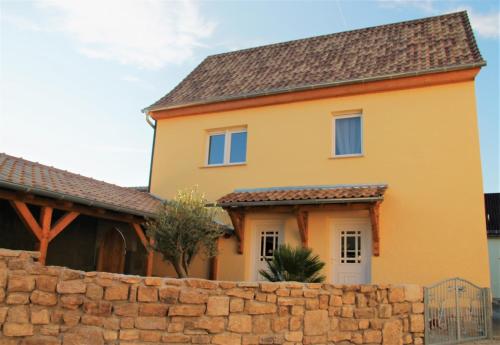 une maison jaune avec un mur en pierre dans l'établissement Casa No7- piano terra, à Naumbourg