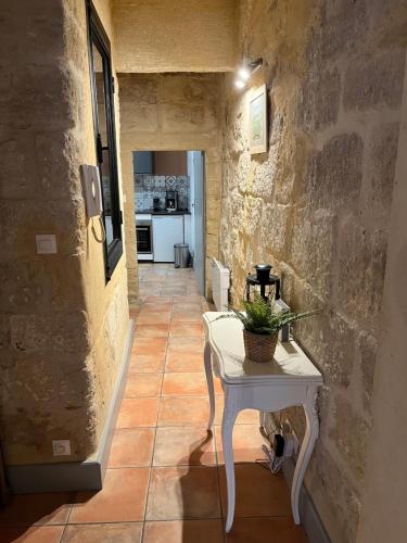 un couloir avec une table et une cuisine dans un bâtiment dans l'établissement Maison de Roche-Uzès Centre Historique L' Ucetia, à Uzès