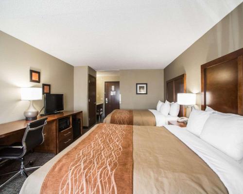 a hotel room with two beds and a desk and a television at Comfort Inn & Suites St Louis-Hazelwood in Hazelwood