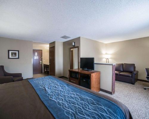 a large hotel room with a bed and a flat screen tv at Comfort Inn & Suites St Louis-Hazelwood in Hazelwood
