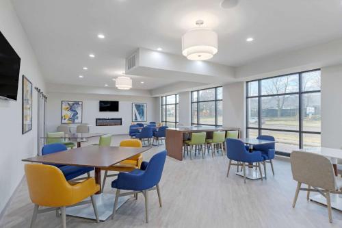 a dining room with a table and chairs and windows at Comfort Inn Detroit - Troy in Clawson