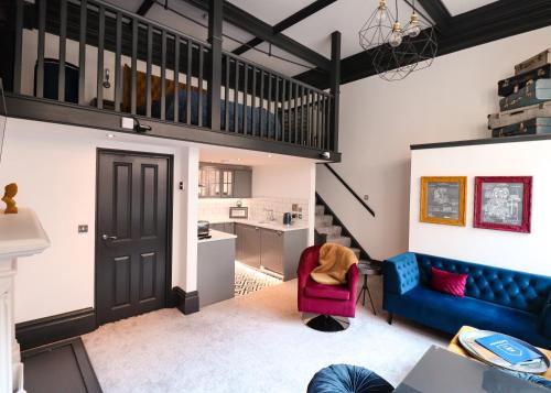 a living room with a blue couch and a red chair at The Vault - boutique apartment in the centre of King's Lynn in Kings Lynn