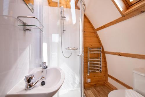 a bathroom with a shower and a sink and a toilet at Humble Bee Farm Glamping in Folkton