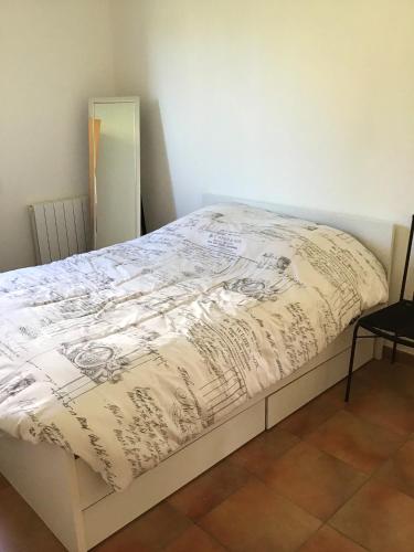 a bedroom with a bed with a white comforter at Appartement charmant à Vallon-Pont-d'Arc, 31 m², piscine privée in Vallon-Pont-dʼArc