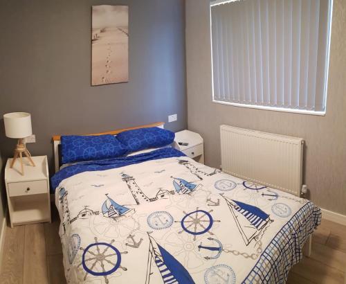a bedroom with a bed with a blue and white comforter at luxury 2-Bed modern chalet in Bridlington in Bridlington