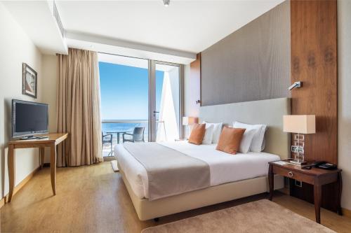 a hotel room with a bed and a large window at Angra Marina Hotel in Angra do Heroísmo
