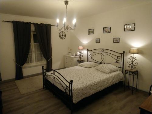 a bedroom with a bed and a chandelier at La Nouvelle Criqueboise in Criquebeuf-en-Caux