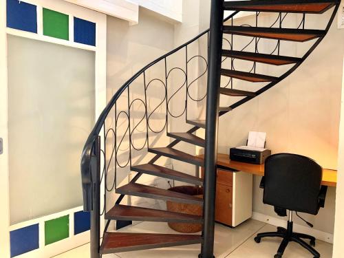 a spiral staircase in a room with a desk at Beachfront Villa Charmant With Private Pool in Koh Samui 