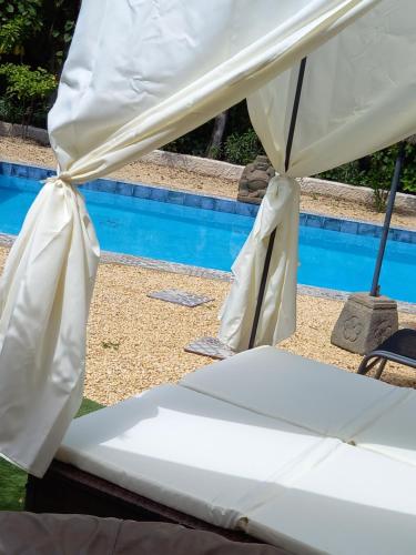 a white bed under a tent next to a pool at Casa Francesca Altea piscina y aparcamiento privado in Altea