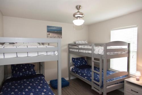 a bedroom with two bunk beds and a window at Beachy Bliss the perfect stay in Navarre