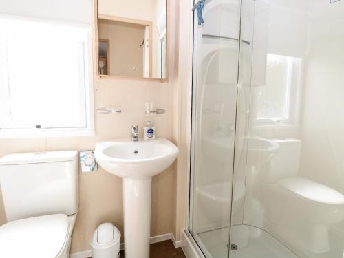 a bathroom with a toilet sink and a shower at 5, Foxburrow Hang in Great Yarmouth