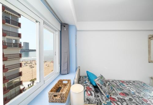 a bedroom with a bed and a window with a beach at El Rincón Playero de María II TOTALMENTE REFORMADO ABRIL 2022 in Benidorm