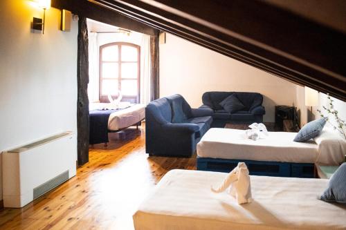 a living room with two beds and a couch at Posada la Leyenda in Santillana del Mar