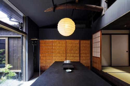 een eetkamer met een tafel en een lamp bij YADORU KYOTO HANARE Washi No Yado in Kyoto