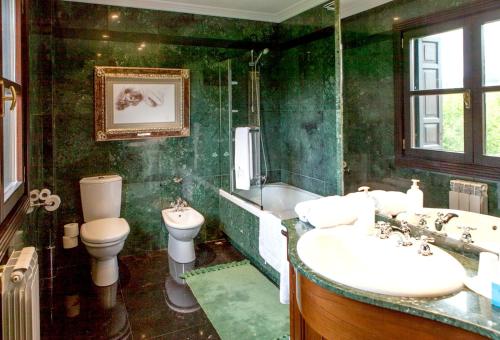 a green bathroom with a toilet and a tub and a sink at Family Home in Oiartzun with Mountain View in Oiartzun