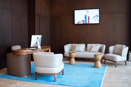uma sala de estar com mobiliário e uma televisão na parede em Pana Boutique Hotel em Shymkent