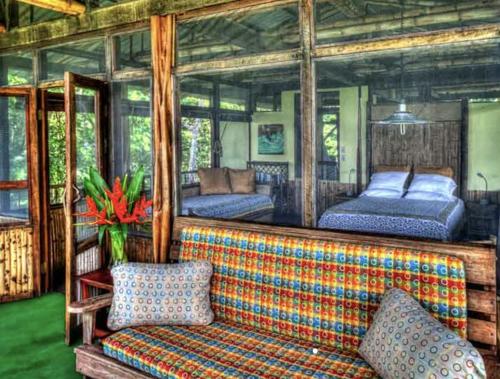 a living room with a couch and two beds at Iguana Lodge Beach Resort in Puerto Jiménez